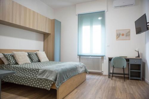 1 dormitorio con cama, escritorio y silla en Casa Boschi in centro città, en Pescara