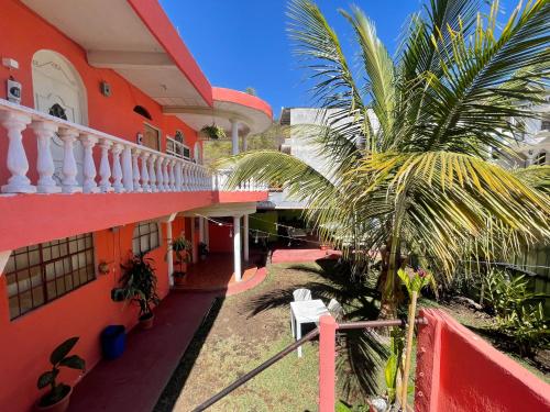 einen Balkon eines Gebäudes mit einer Palme in der Unterkunft Hotel Posada Gutierrez in Panajachel