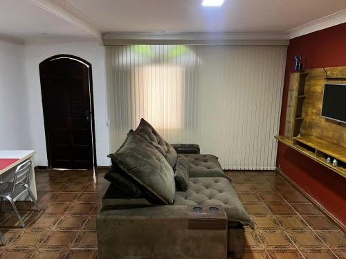 a living room with a couch with pillows on it at Linda Casa com Estacionamento in Juiz de Fora