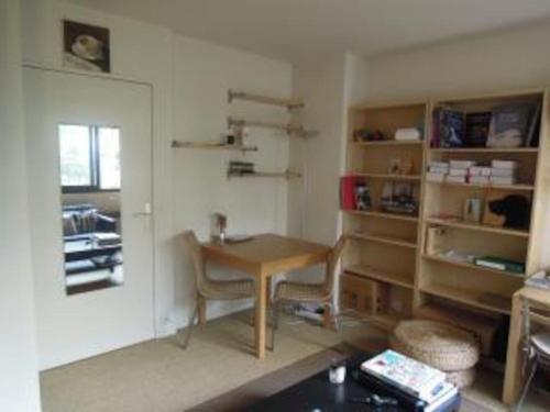 Cette chambre comprend un bureau, une table et des étagères. dans l'établissement Studio très calme Montparnasse, à Paris