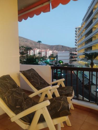 a balcony with chairs and a view of a city at Precioso estudio en Los Cristianos in Los Cristianos