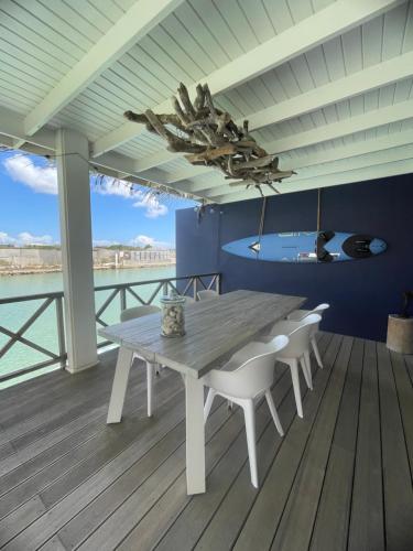 una mesa y sillas en una terraza con vistas al océano en Villa Bahia Blue en Kralendijk