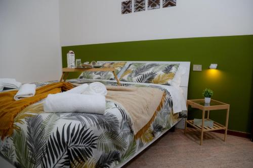 1 dormitorio con 1 cama con pared verde en Guest House Fontanesi, en Reggio Emilia