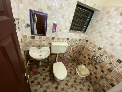 a bathroom with a toilet and a sink at KOKARI,S HOMESTAY 101 BY AL MANAL in Bhatkal