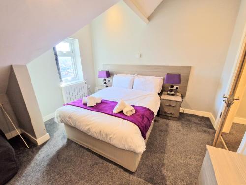 a bedroom with a large bed with two towels on it at Central Reading Modern 3BR flat - Walk to station and high street in Reading