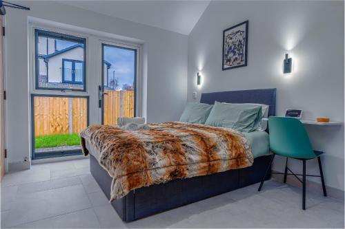 a bedroom with a bed and a desk and a window at Cosy single storey bungalow with garden, parking in Bristol