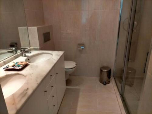 Un baño con inodoro, lavabo y ducha. en Penthouse Apartment, en Benissa