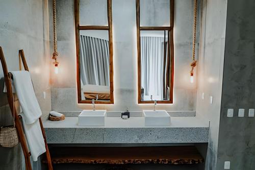 ein Badezimmer mit zwei Waschbecken und zwei Spiegeln in der Unterkunft Casa moderna e confortável com vista mar in Barra Grande