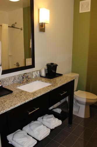 a bathroom with a sink and a toilet and a mirror at Sleep Inn & Suites Odessa near University in Odessa