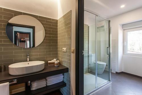 a bathroom with a sink and a mirror and a shower at Casa do Cesteiro in Santiago de Compostela