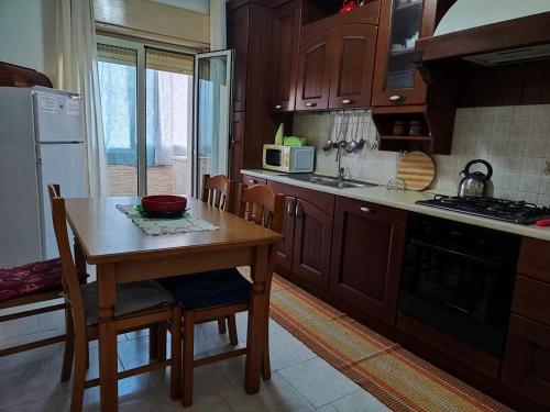 una cocina con armarios de madera y una mesa con sillas. en Trapani love, en Trapani