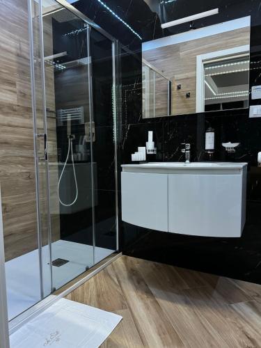 a bathroom with a glass shower and a sink at Le Suite Piazza Nuova in Foggia