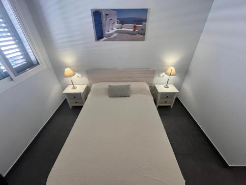 1 dormitorio con 1 cama grande y 2 mesitas de noche en Apartamentos Arenas Altamar, en Alcossebre