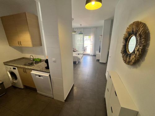 a kitchen with a sink and a mirror on the wall at Apartamentos Arenas Altamar in Alcossebre