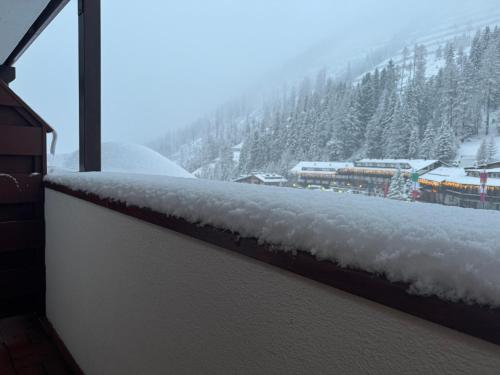 a snow covered balcony with a view of a mountain at Ski Lodge Pampeago in Tesero