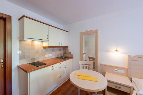 una pequeña cocina con mesa y fregadero en Appartement Tschivon, en Scena