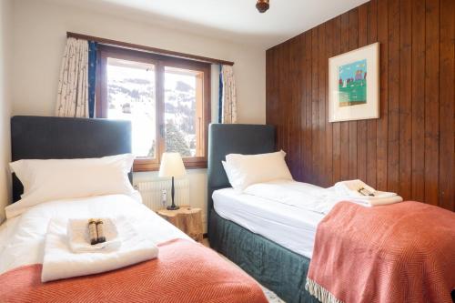 ein Schlafzimmer mit zwei Betten mit Kreuzen in der Unterkunft La Ruinette-spacious 3-bed Apt In Verbier Centre in Verbier