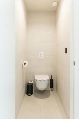 a bathroom with a white toilet in a room at Amarilla Golf Residences in San Miguel de Abona
