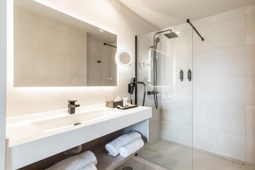 y baño blanco con lavabo y ducha. en Amarilla Golf Residences, en San Miguel de Abona