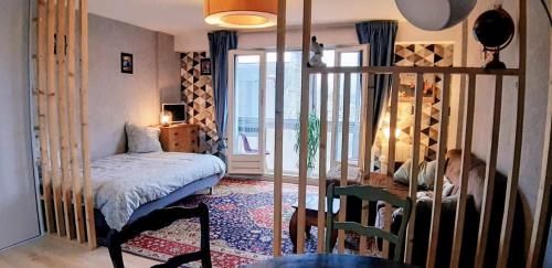 een slaapkamer met een bed, een tafel en een raam bij l'octroi in Cherbourg en Cotentin