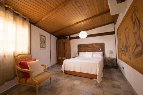 1 dormitorio con 1 cama grande y 1 silla en villa alba ibiza en Santa Eulalia del Río