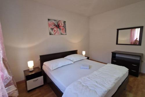 um quarto com uma cama com duas mesas de cabeceira e dois candeeiros em Apartman Valentina em Podstrana