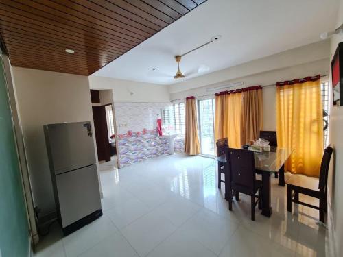 Il comprend une cuisine et une salle à manger avec un réfrigérateur et une table. dans l'établissement Entire place-4BHK Apartment Bashundhara R/A, à Dhaka