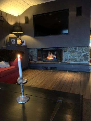 a candle in a living room with a fireplace at Roni Chalet Hemsedal - Holdeskaret in Hemsedal