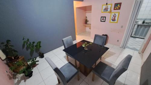 une salle à manger avec une table noire et des chaises bleues dans l'établissement EDF: RUBI 184, à Récife