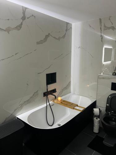 La salle de bains est pourvue d'une baignoire et de toilettes. dans l'établissement Élégance Alpine à Morbier, à Morbier