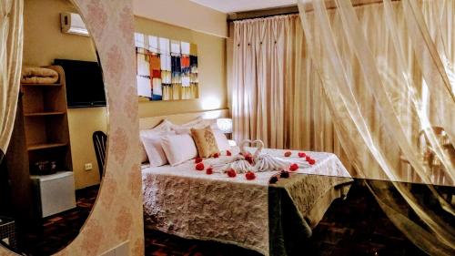 Un dormitorio con una cama con adornos. en Vespasiano Hotel Telêmaco Borba en Telêmaco Borba