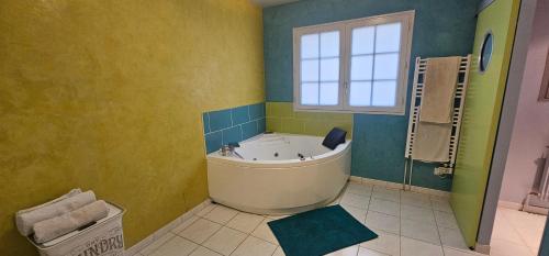 baño grande con bañera y ventana en Suite de 38m2 spécial JO, en Veneux-les-Sablons