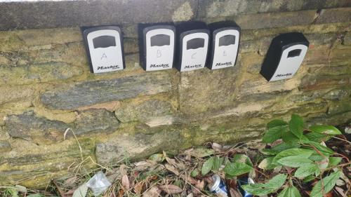 a stone wall with three parking meters and three toasters at Flat 501 Chic Apartment Living in Yeadon