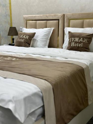 two large beds with white sheets and pillows at Iyman Hotel in Yakkasaray