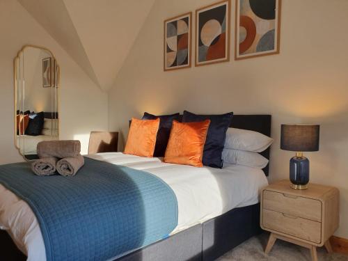 a bedroom with a large bed with orange and blue pillows at Dunabban Road, Inverness city in South Kessock