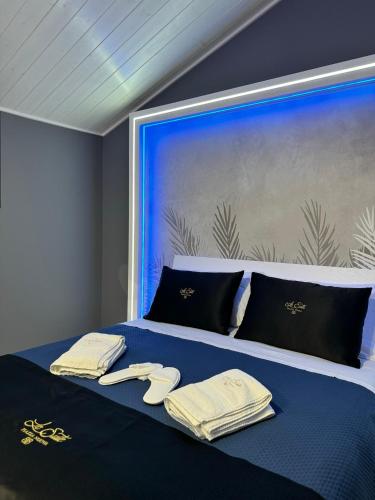 un letto con asciugamani e parete blu di Le Suite Piazza Nuova a Foggia