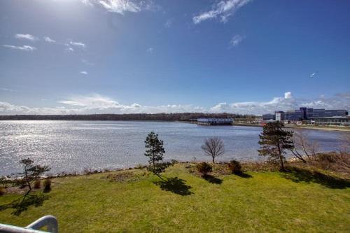 une grande masse d'eau avec des arbres dans l'herbe dans l'établissement Strandhotel, App 1SH308, à Heiligenhafen