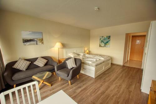 - un salon avec un lit et un canapé dans l'établissement Strandhotel, App 1SH308, à Heiligenhafen