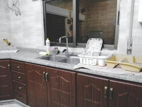 a kitchen counter with a sink and a mirror at Breeze House in Kafr Khall