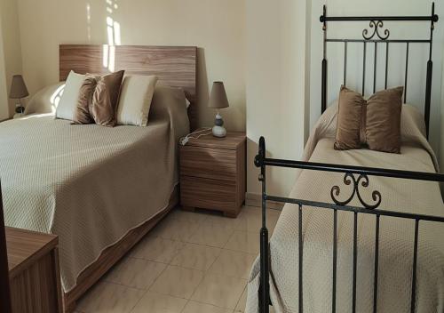 a bedroom with a bed and a night stand with a lamp at Domus Parva, appartamento con giardino in Pompei