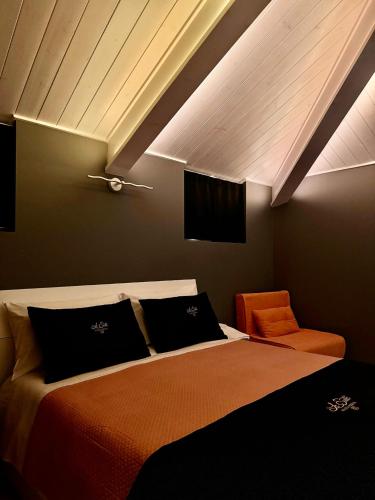 a bedroom with a bed and an orange chair at Le Suite Piazza Nuova in Foggia
