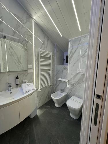 a bathroom with two sinks and a toilet and mirror at Le Suite Piazza Nuova in Foggia