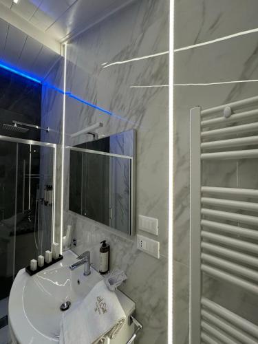 a white bathroom with a sink and a shower at Le Suite Piazza Nuova in Foggia