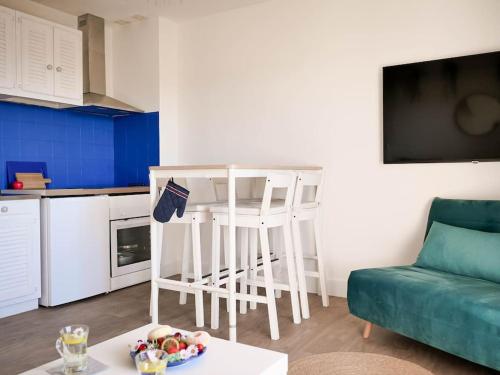 un salon avec un canapé et une table dans une cuisine dans l'établissement Appartement détente avec vue sur le petit port, à Hyères