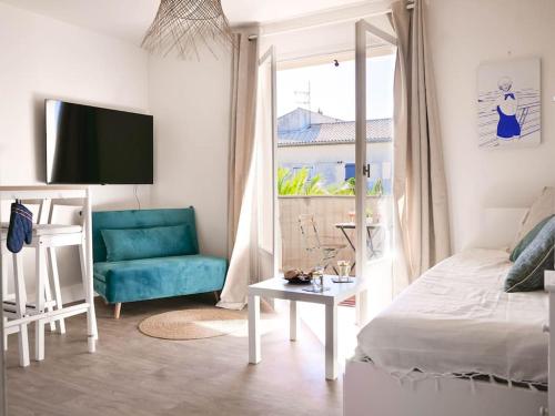 ein Wohnzimmer mit einem Bett und einem blauen Sofa in der Unterkunft Appartement détente avec vue sur le petit port in Hyères
