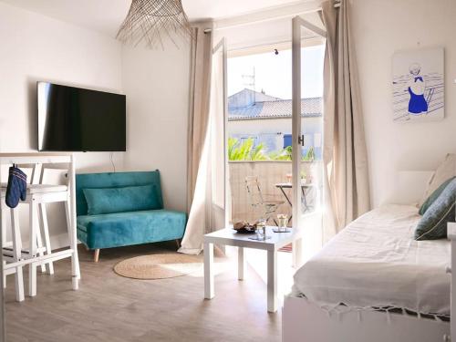 - un salon avec un lit et un canapé bleu dans l'établissement Appartement détente avec vue sur le petit port, à Hyères