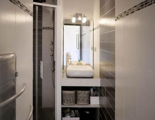 ein Bad mit einem Waschbecken und einem Spiegel in der Unterkunft Appartement détente avec vue sur le petit port in Hyères
