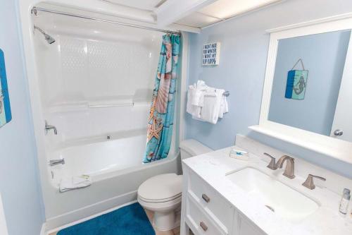 a bathroom with a toilet and a sink and a mirror at Atlantica Resort in Myrtle Beach