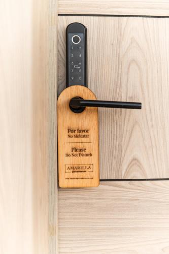 a wooden door handle with a remote control on it at Amarilla Golf Residences in San Miguel de Abona