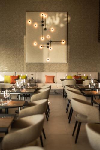 a restaurant with tables and chairs and a chandelier at Amarilla Golf Residences in San Miguel de Abona